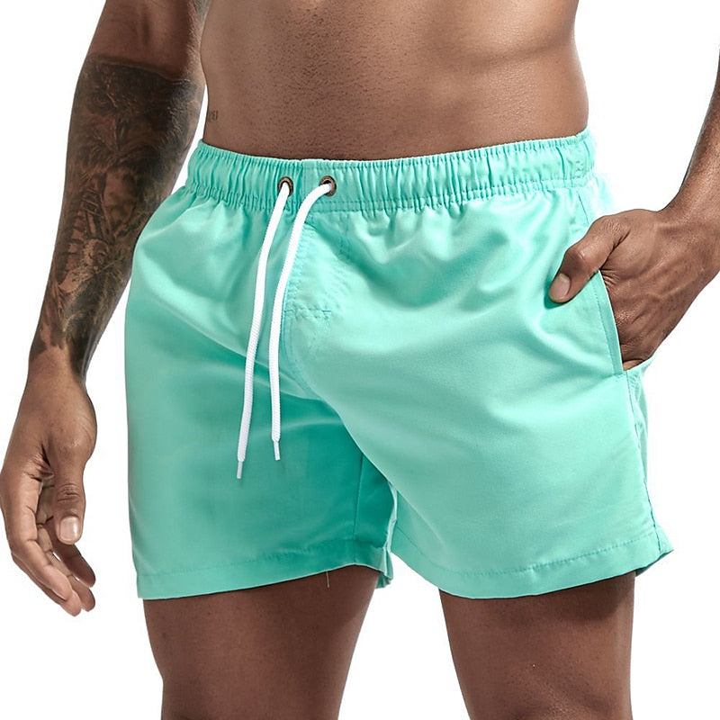 Mint green men swim shorts with elastic waist, drawstring, and lightweight swim trunks style