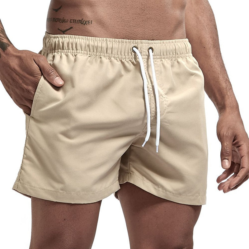 Beige men swim shorts with elastic waist, drawstring, and clean minimal beach shorts style