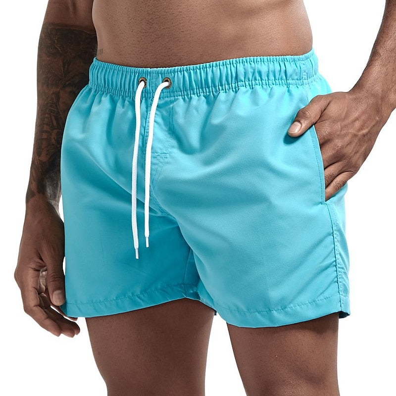 Turquoise men swim shorts with elastic waist, drawstring, and side pocket in a beach style