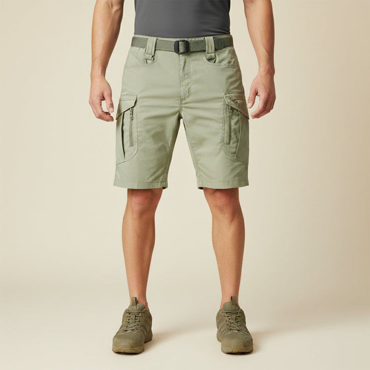 Model wearing light khaki tactical cargo shorts with pockets and olive belt