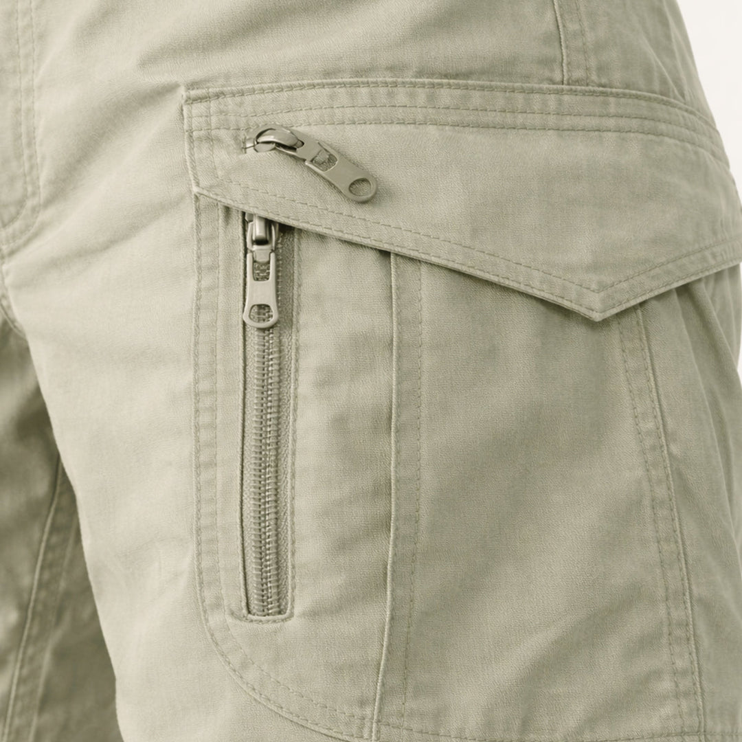 Close-up of light khaki cargo shorts side pocket with zipper and flap detail