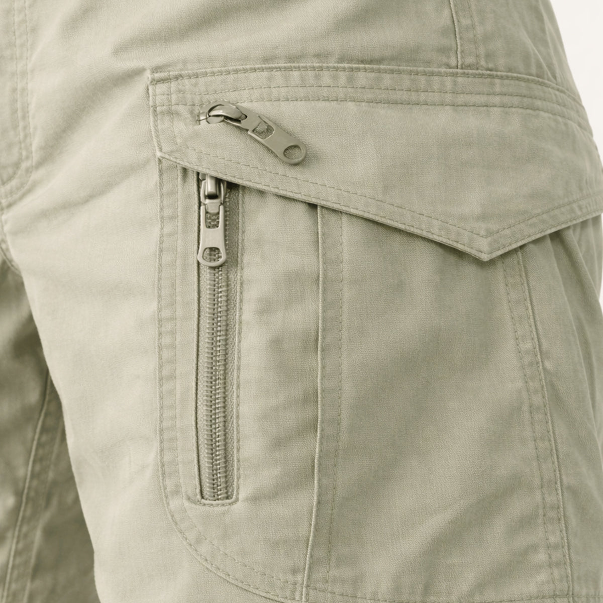 Close-up of light khaki cargo shorts side pocket with zipper and flap detail