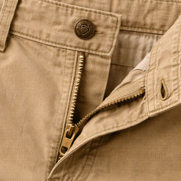 Close-up of khaki cargo shorts waistband and front zipper with button closure