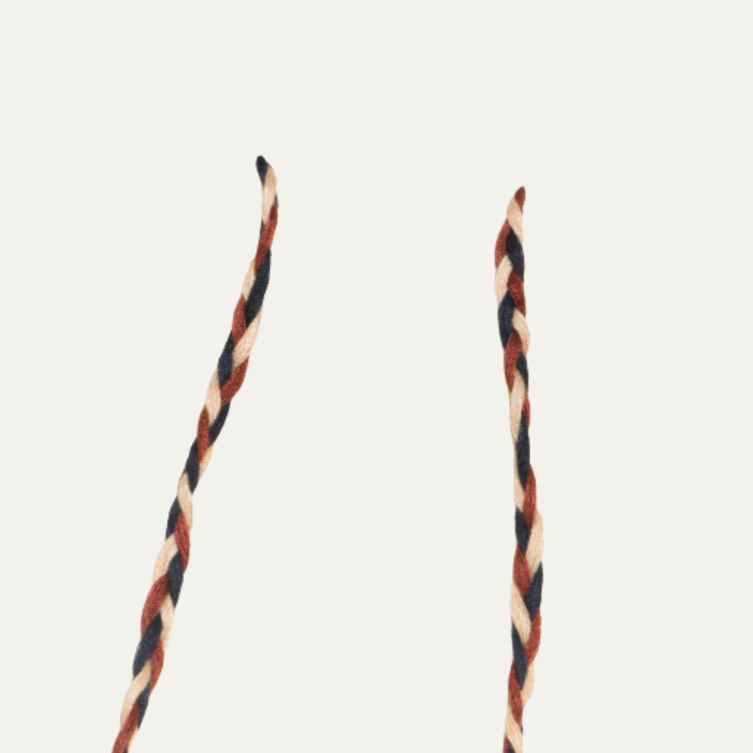 Close-up of braided drawstring cords with yellow beads on textured cargo shorts