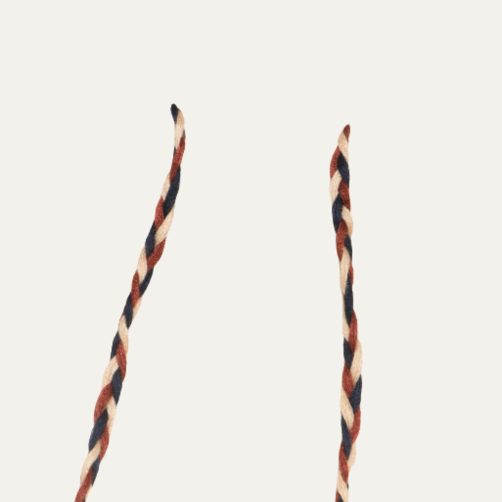 Close-up of braided drawstring cords with yellow beads on textured cargo shorts