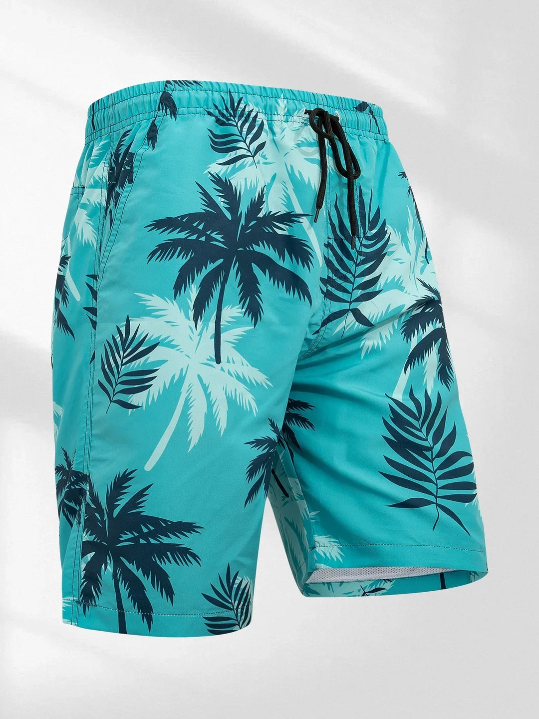 Turquoise palm print swim shorts with elastic waistband and black drawstring on a white background