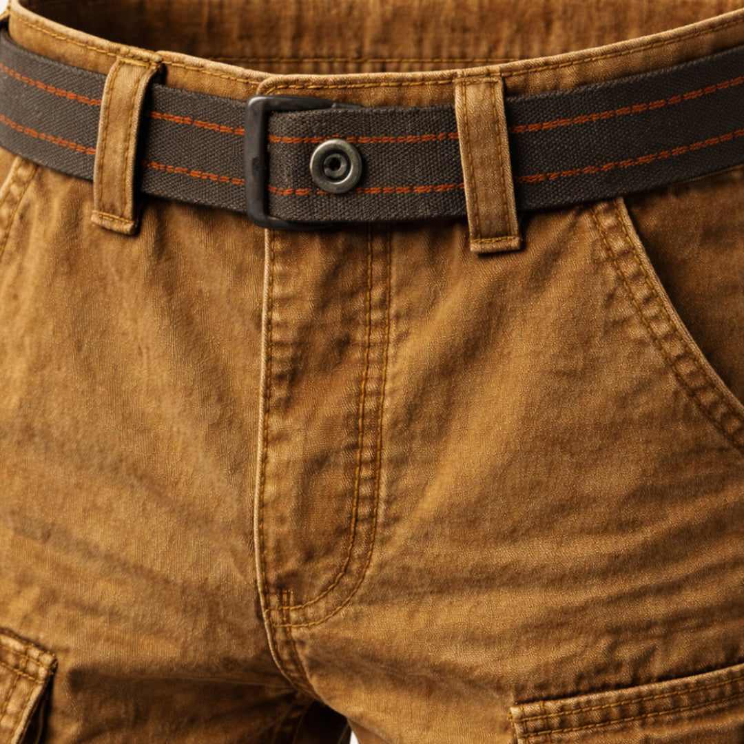 Close-up of tan men's cargo shorts waistband with stitched belt and front pocket seam detail