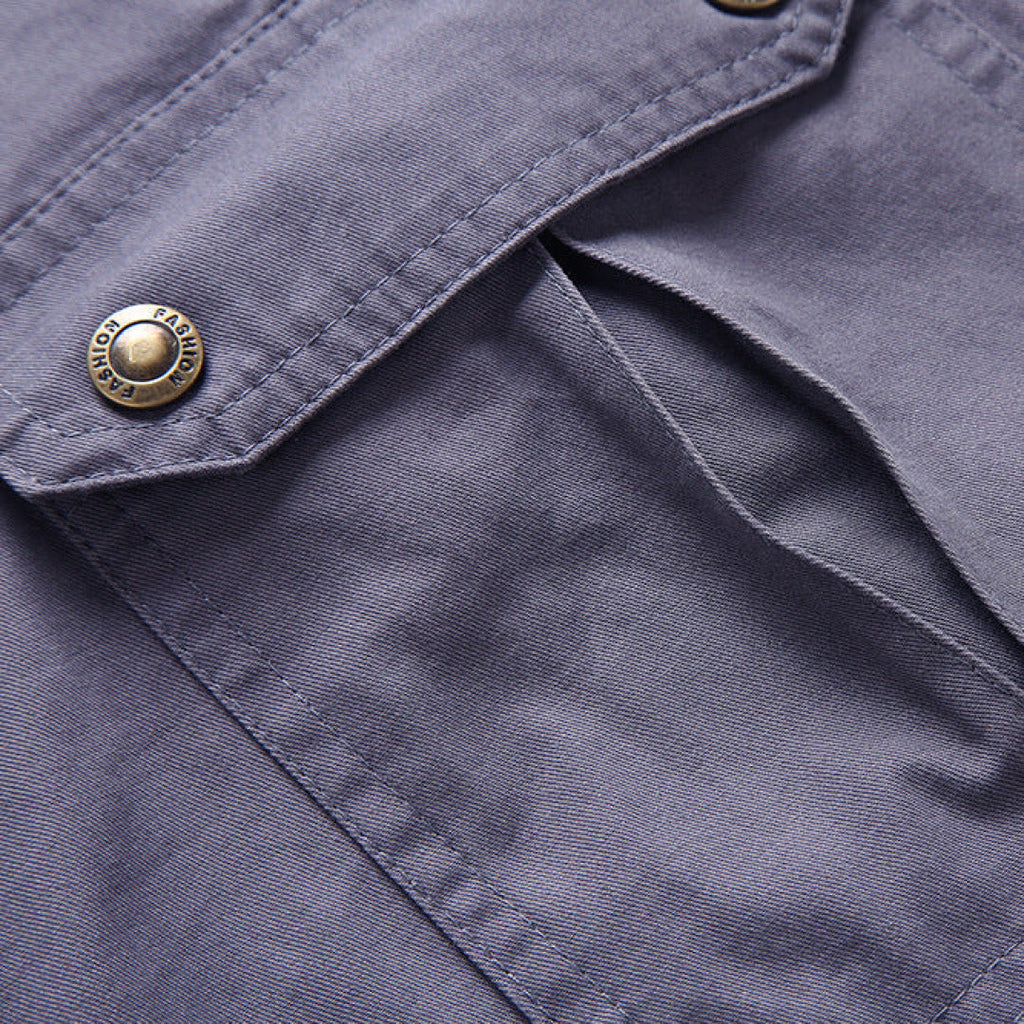 Close-up of gray cargo shorts fabric and flap pocket with snap button closure