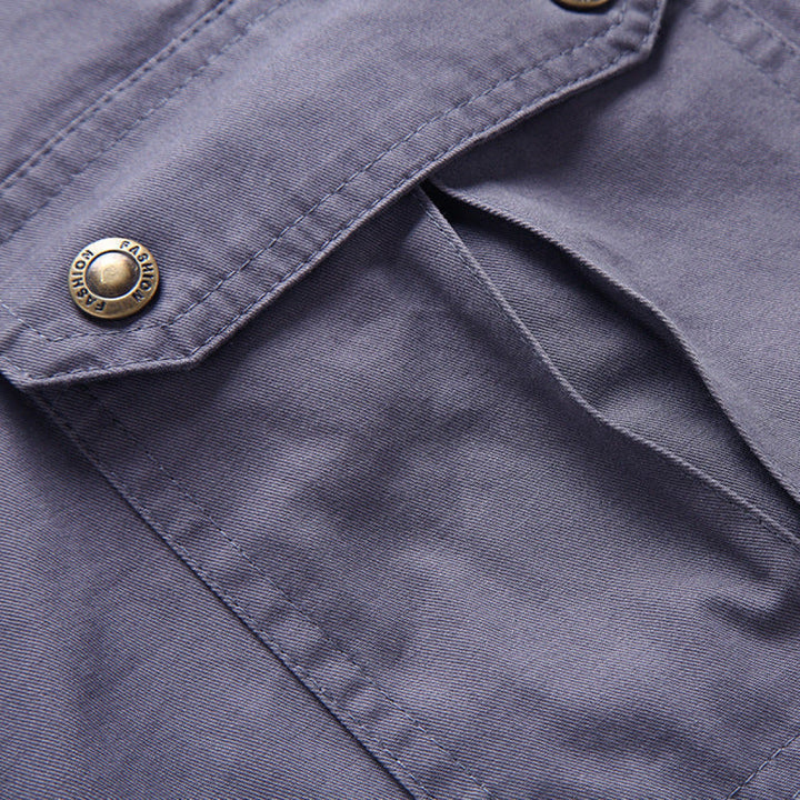 Close-up of gray cargo shorts fabric and flap pocket with snap button closure