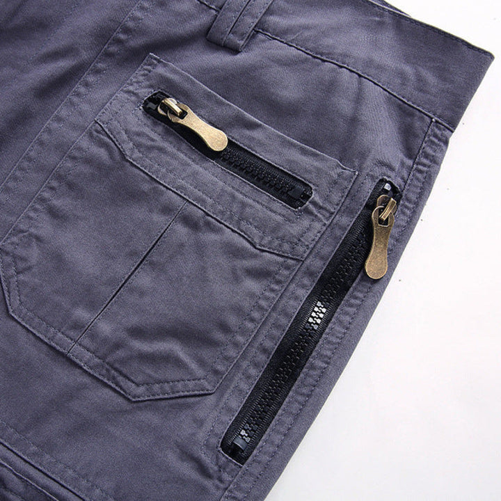 Close-up of gray men's cargo shorts with zip pocket details and knee length cut