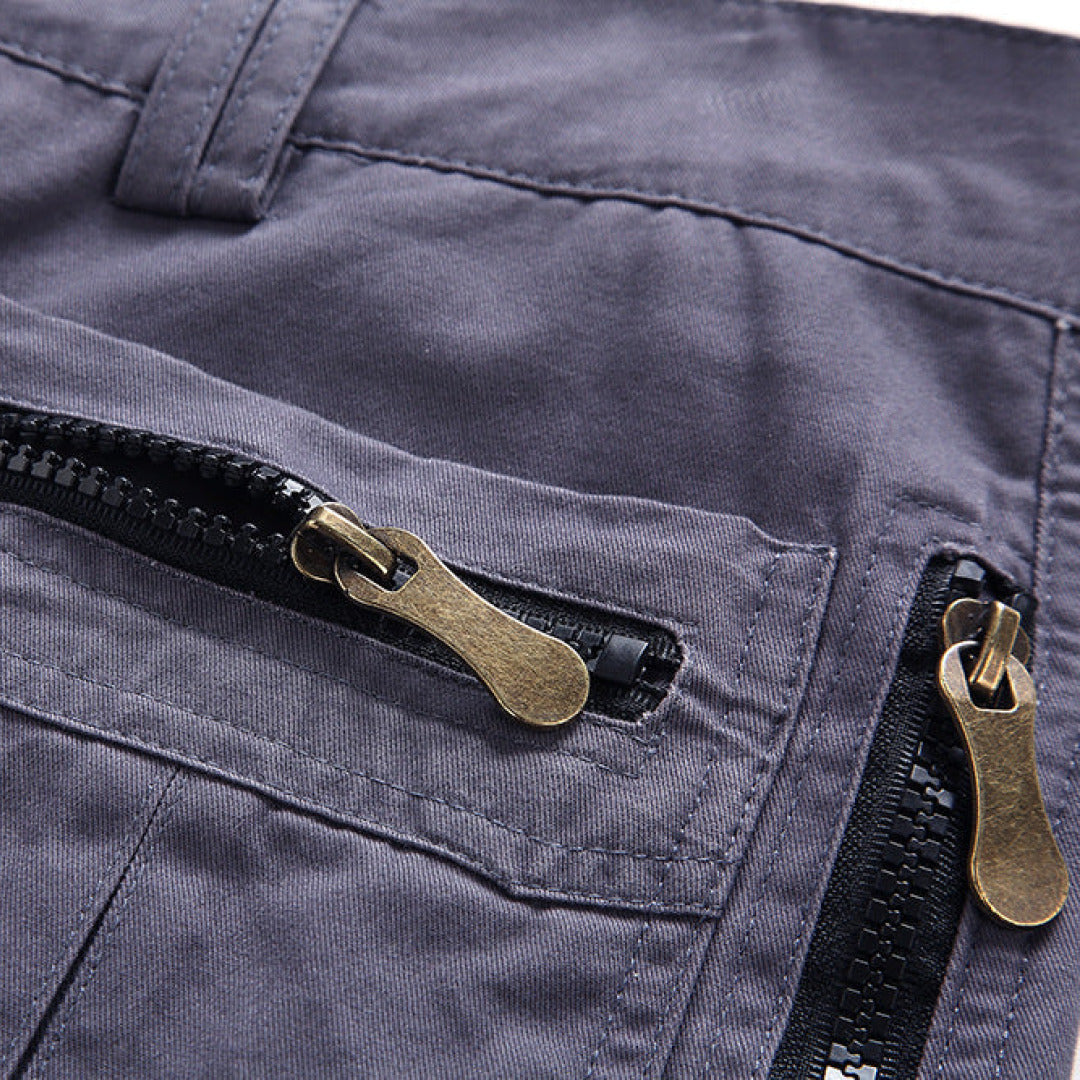 Close-up of zip pocket cargo shorts with brass zipper pulls and utility pocket