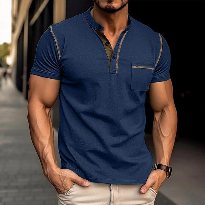 Men's navy Henley shirt worn with beige pants, featuring a pocket and short sleeves