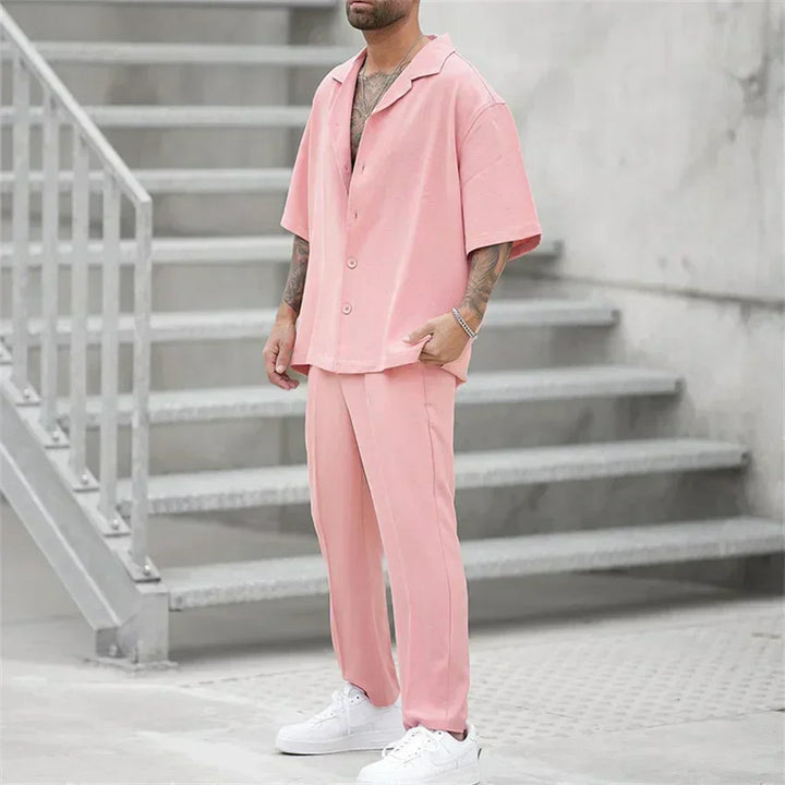 Side view of men's pink short sleeve shirt pants set with loose fit and button front top