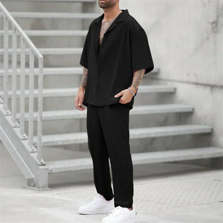 Men's black short sleeve shirt and pants set with relaxed fit, shown in a full length view
