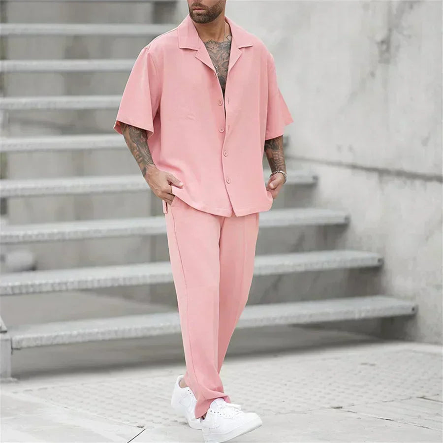 Men's pink short sleeve shirt pants set in angled view, casual summer outfit with white sneakers
