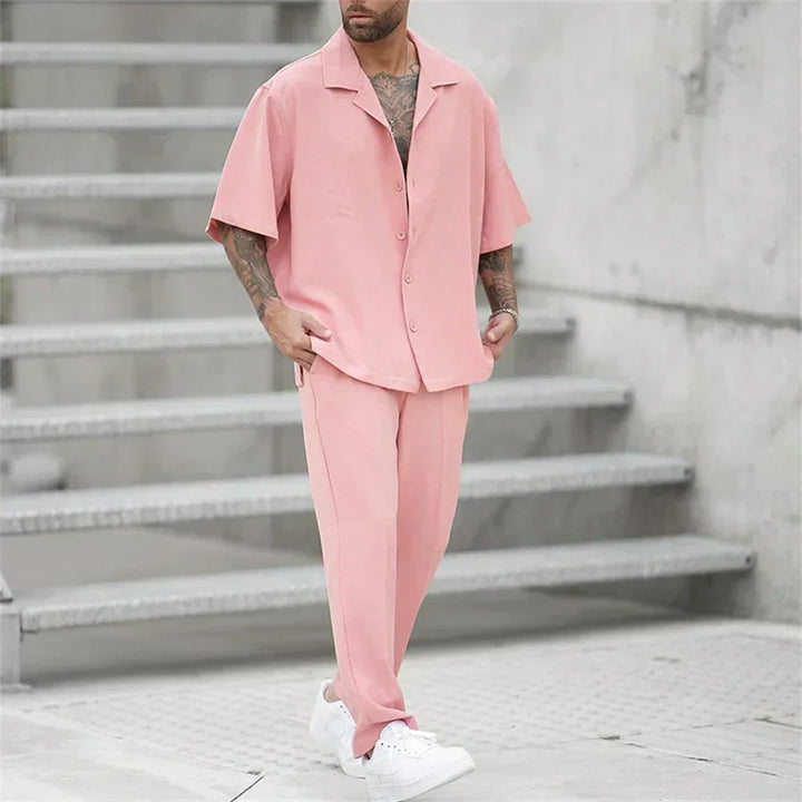 Men's pink short sleeve shirt pants set in angled view, casual summer outfit with white sneakers