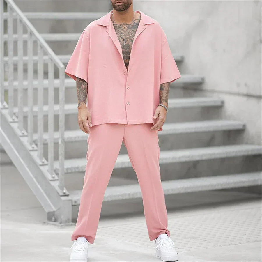 Men's pink short sleeve shirt and pants set with relaxed fit, worn with white sneakers