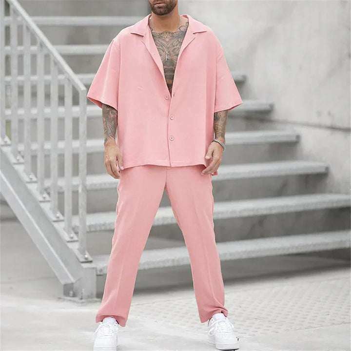 Men's pink short sleeve shirt and pants set with relaxed fit, worn with white sneakers