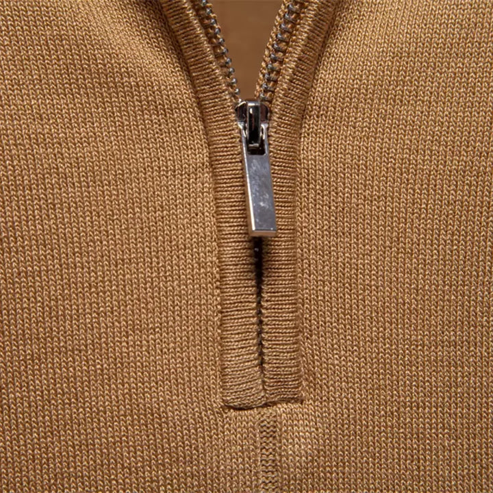 Close-up of tan knit polo shirt zipper placket showing textured fabric and metal zip detail