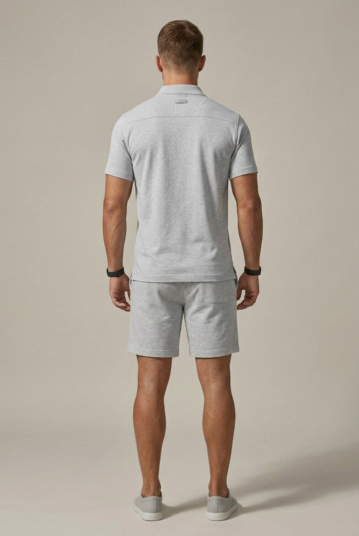 Back view of light gray short sleeve polo shirt and shorts set with relaxed fit and clean hem details
