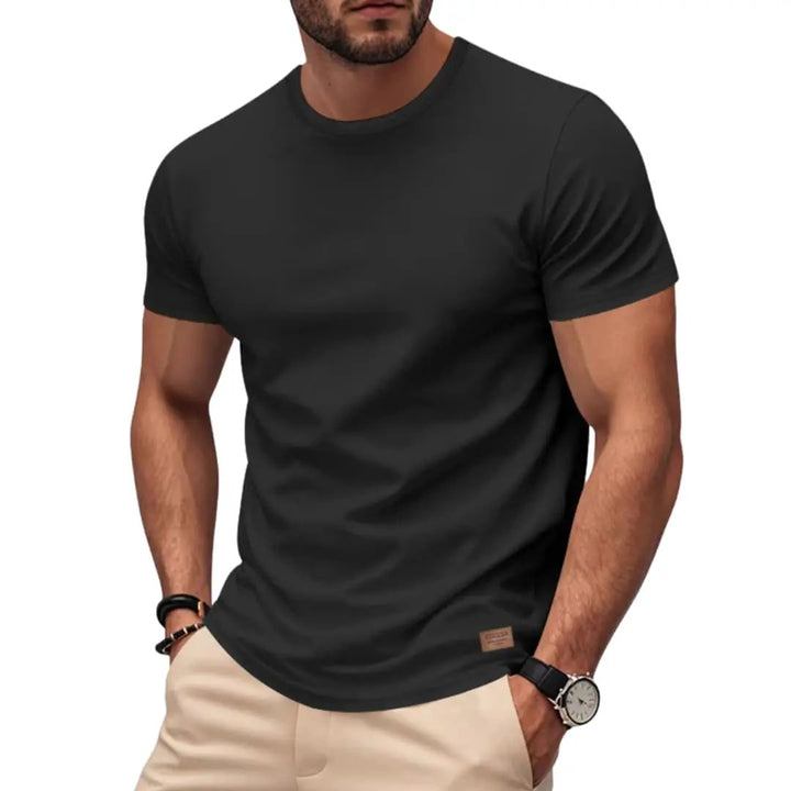 Black crew neck short sleeve sports T-shirt worn with casual pants in a fitted style