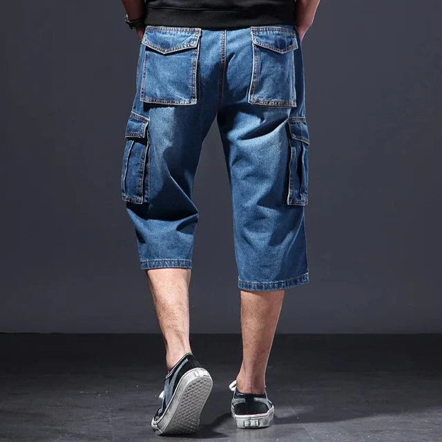 Back view of blue denim cargo shorts with large rear pockets and knee length cut