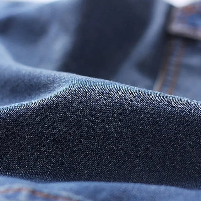 Close-up of dark blue denim fabric texture on cargo shorts with soft faded finish