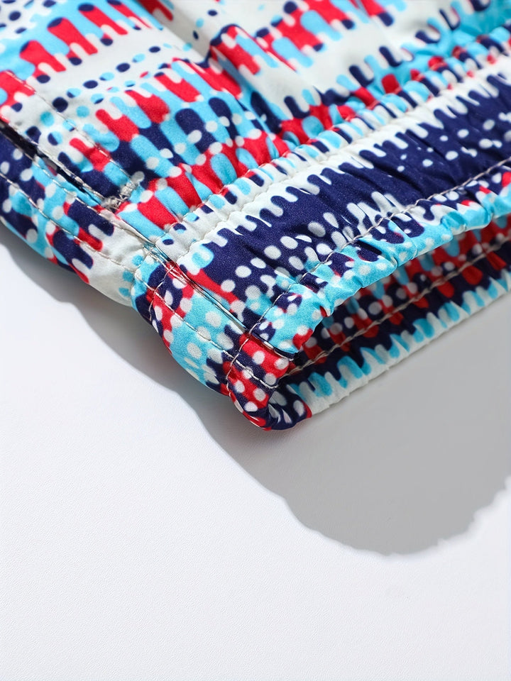 Close-up of men's swim shorts hem showing stitched seam and bold blue red navy graphic print