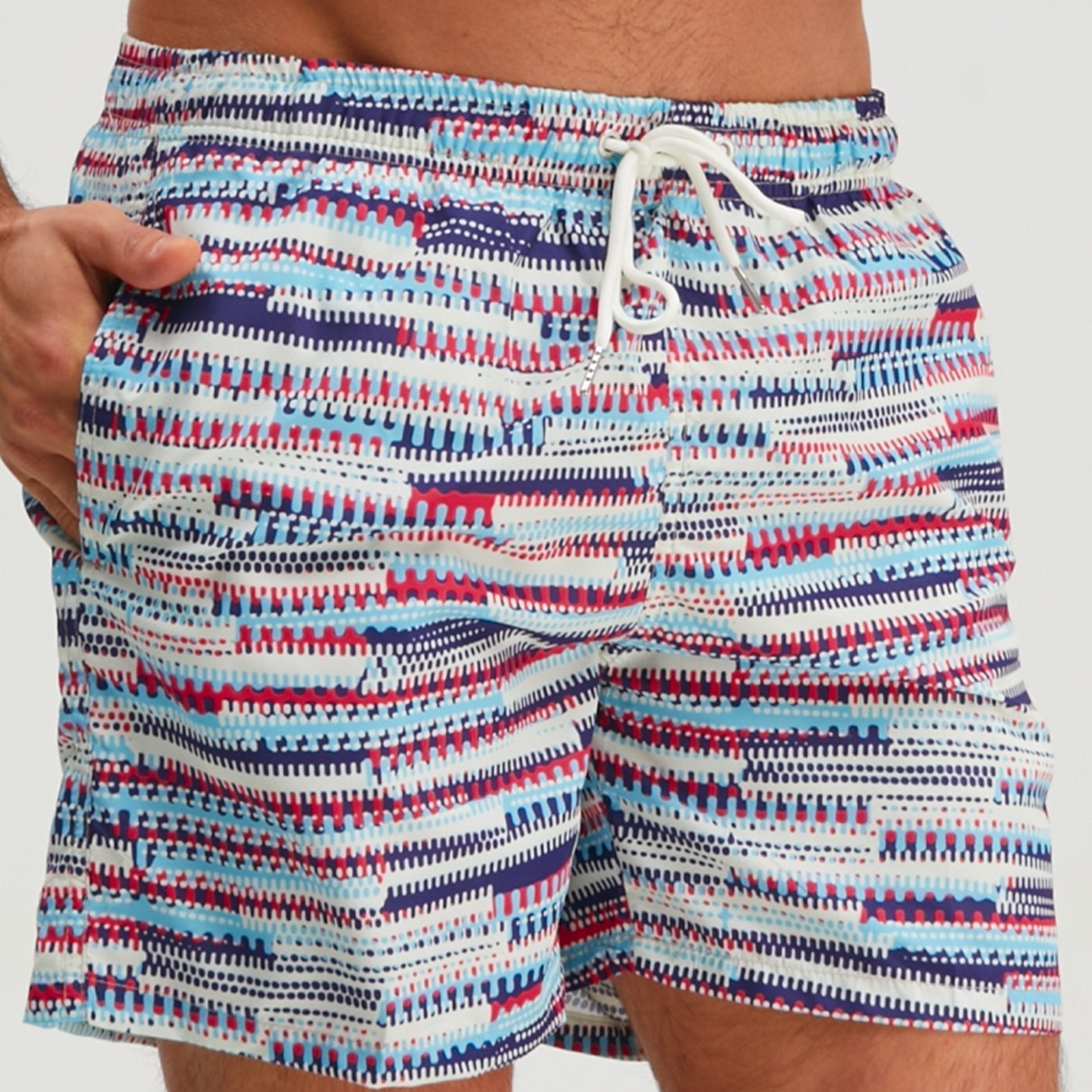Close-up front view of men's graphic swim shorts showing waistband, drawstring, and bright striped print