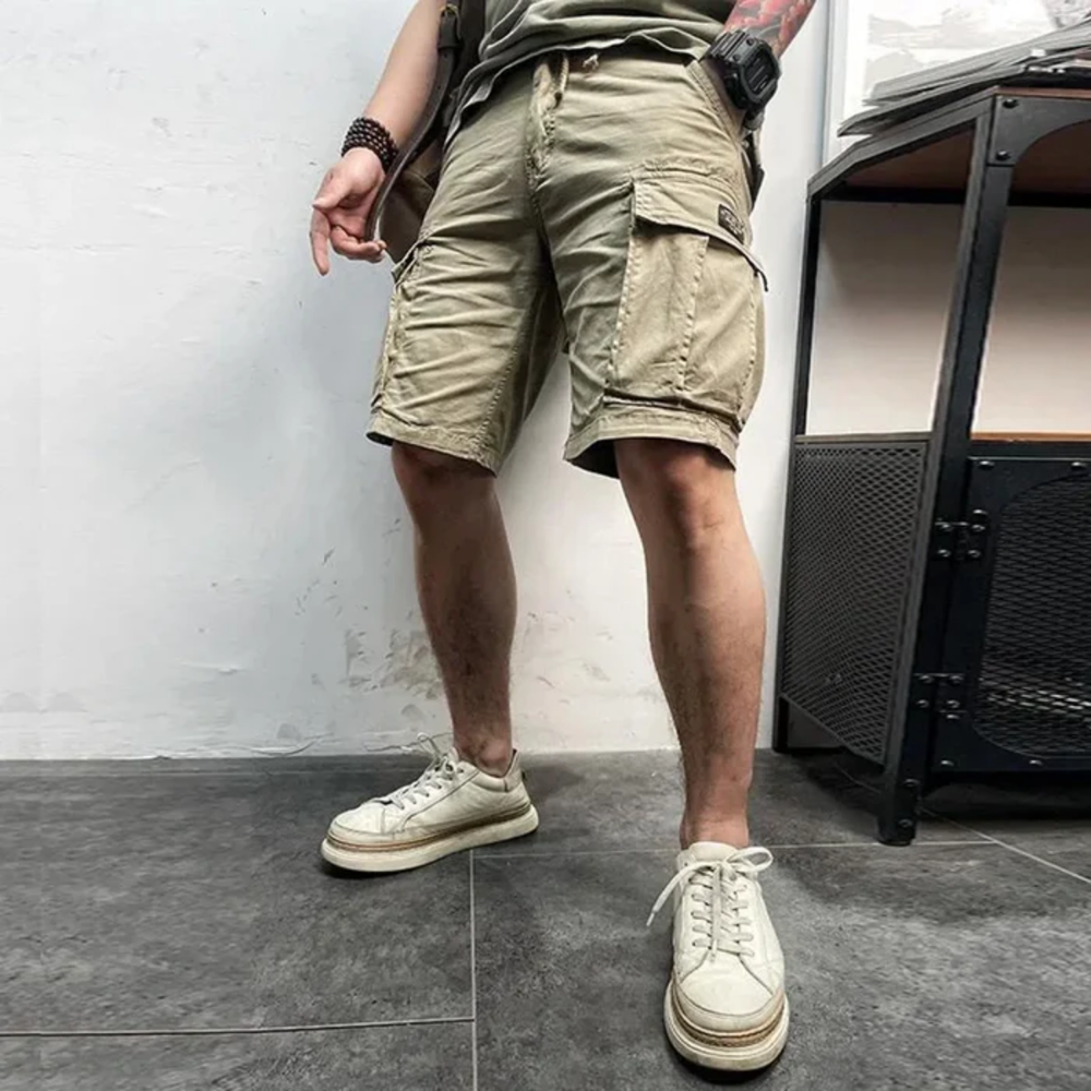 Model wearing khaki cargo shorts with pockets, casual summer shorts with white sneakers