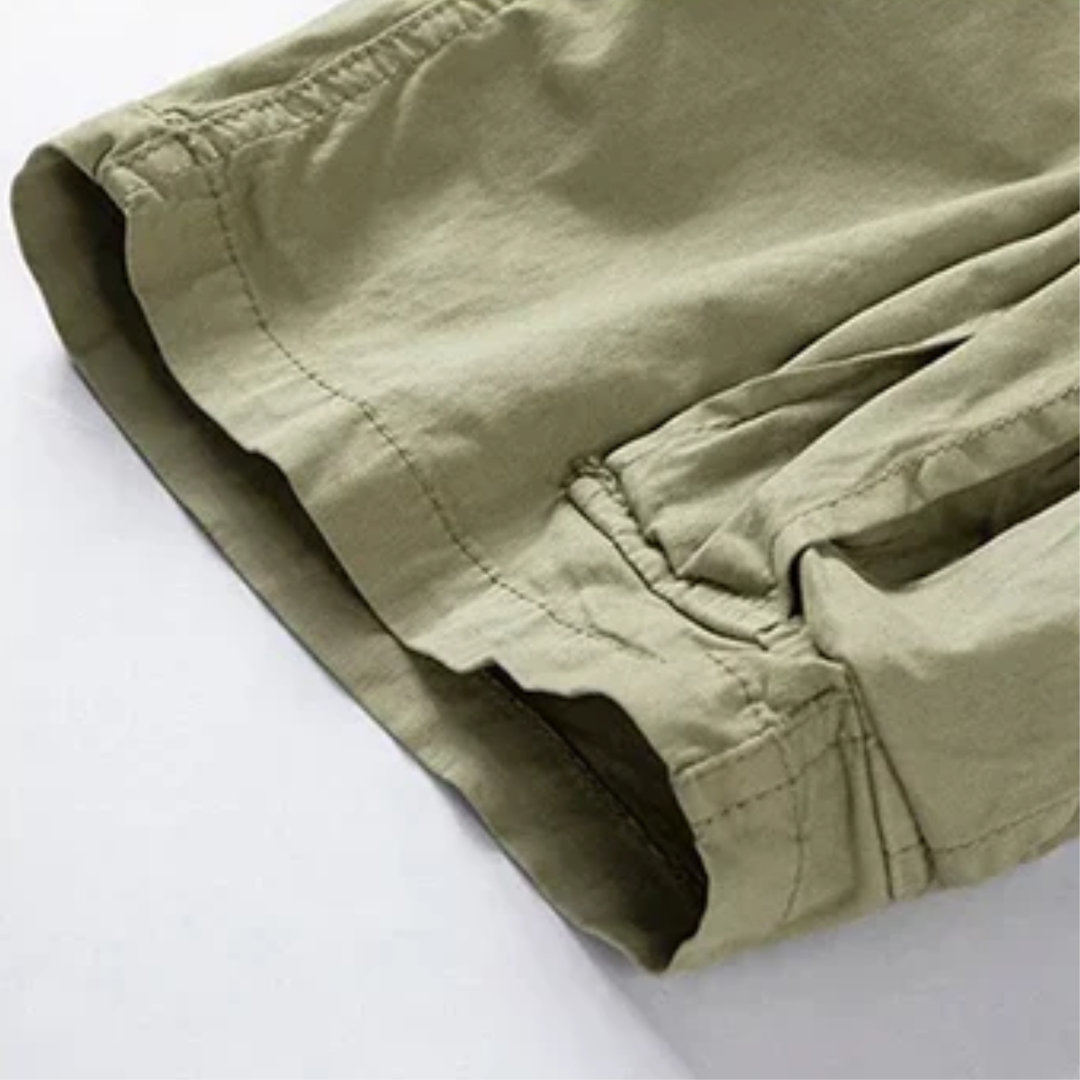 Close-up of khaki cargo shorts leg opening with stitched hem and pocket seam detail