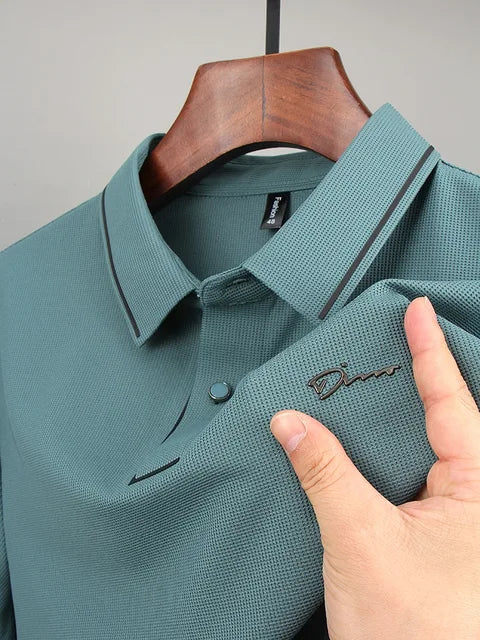 Green pique knit polo shirt close-up with button collar and embroidered chest detail