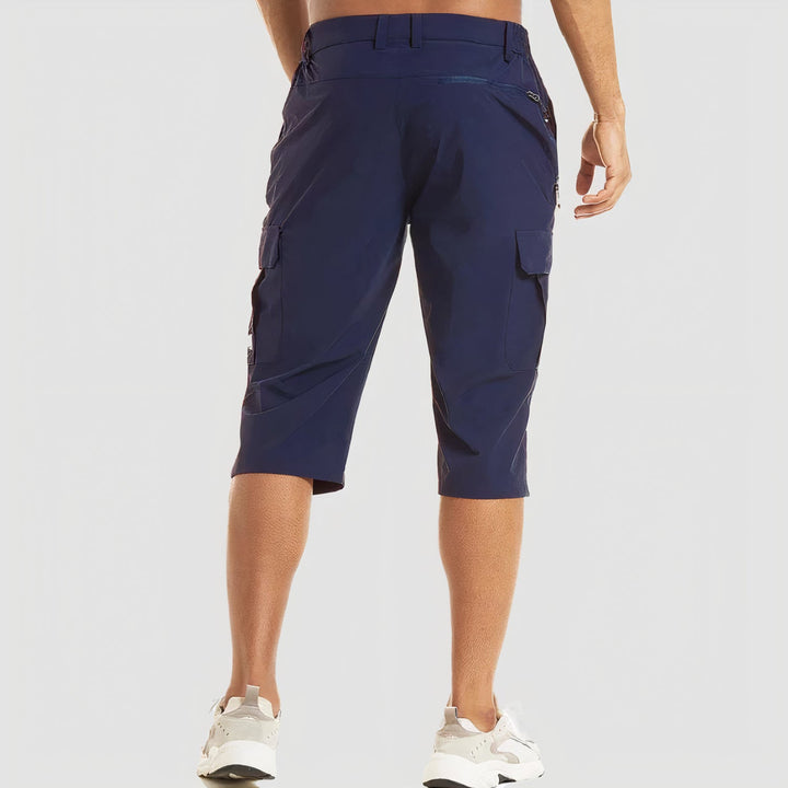 Rear angled view navy men's cargo shorts with zipper pocket detail and knee-length fit