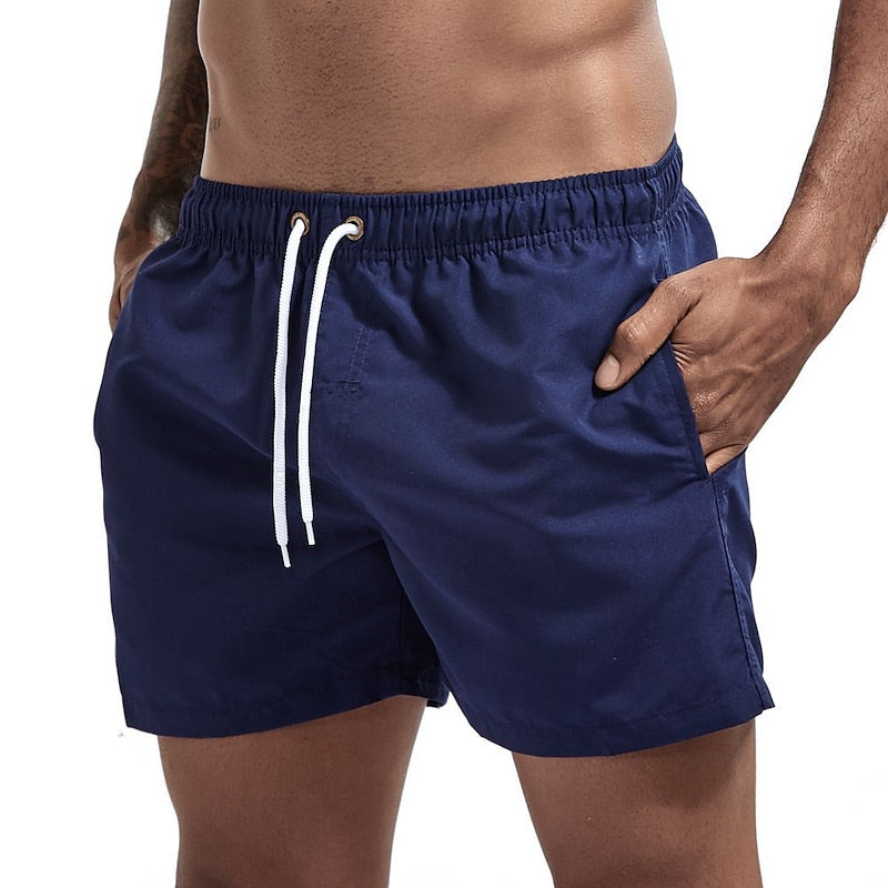 Navy blue men's swim shorts in quick dry material with drawstring waist and pockets, front view