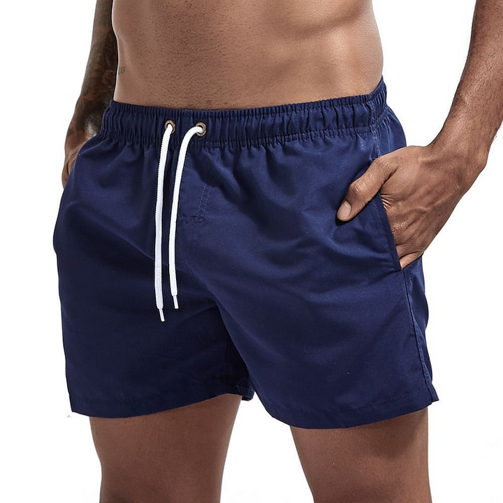 Navy blue men's swim shorts in quick dry material with drawstring waist and pockets, front view