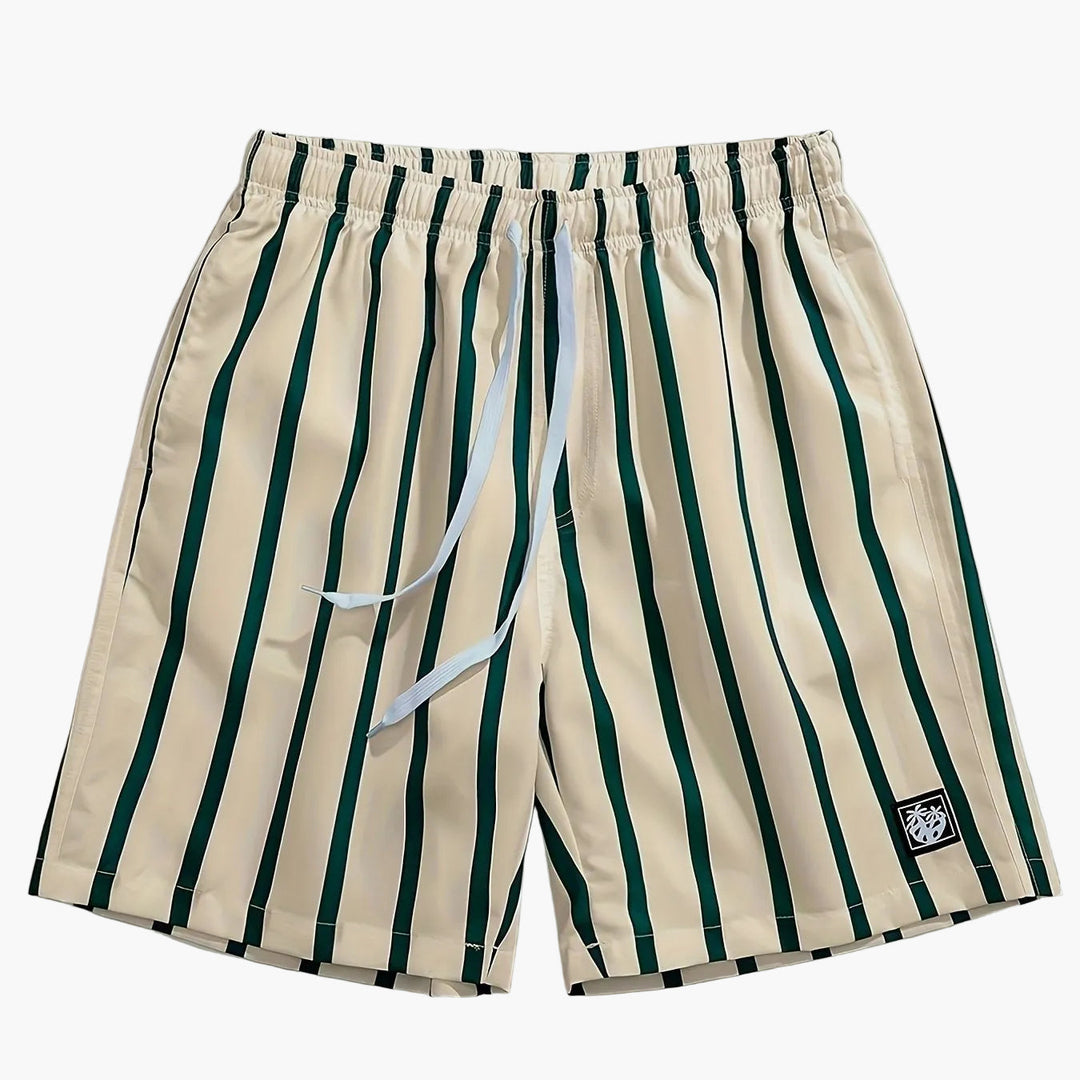Men's beige swim shorts with dark green vertical stripes, drawstring waist, and logo patch