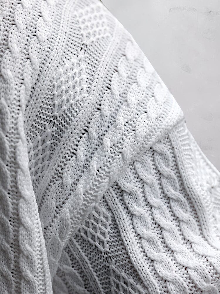 Close up of white cable knit fabric showing raised knit texture and pattern detail