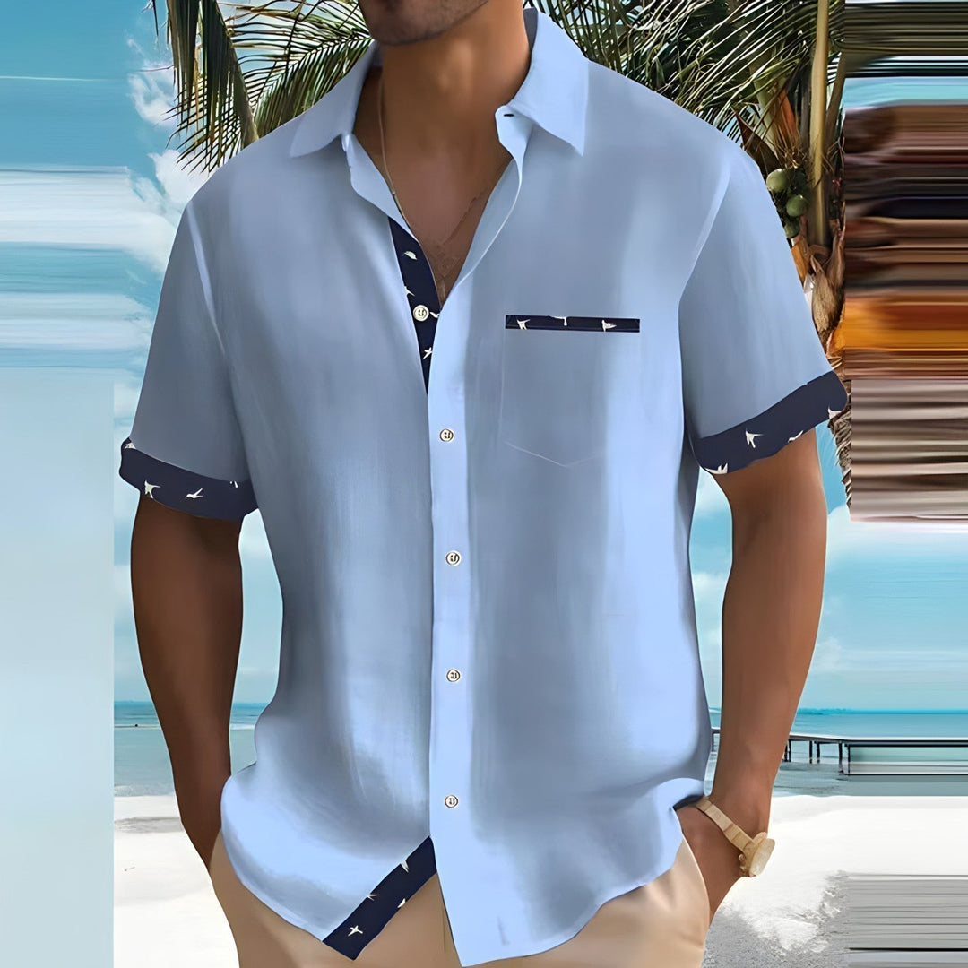 Light blue short sleeve button down shirt for men with navy patterned sleeve cuffs and pocket detail