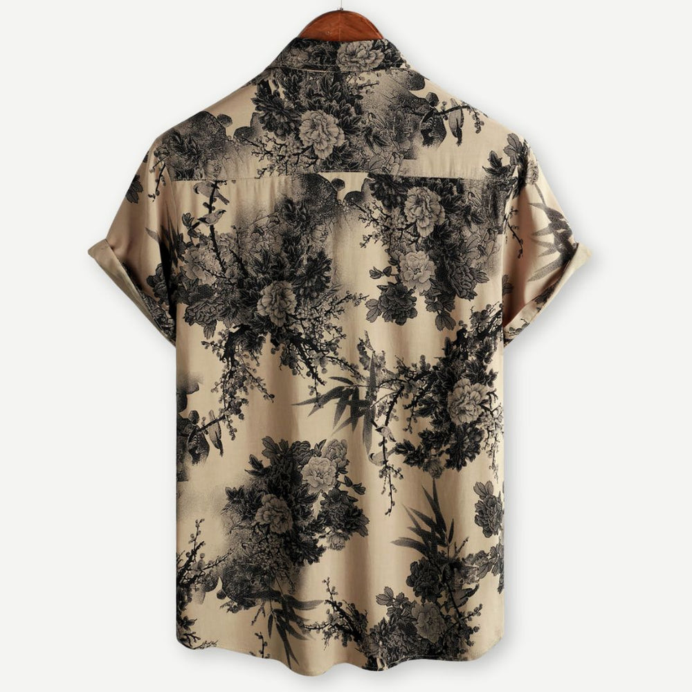 Back view of beige men's floral shirt with black allover botanical pattern and short sleeves