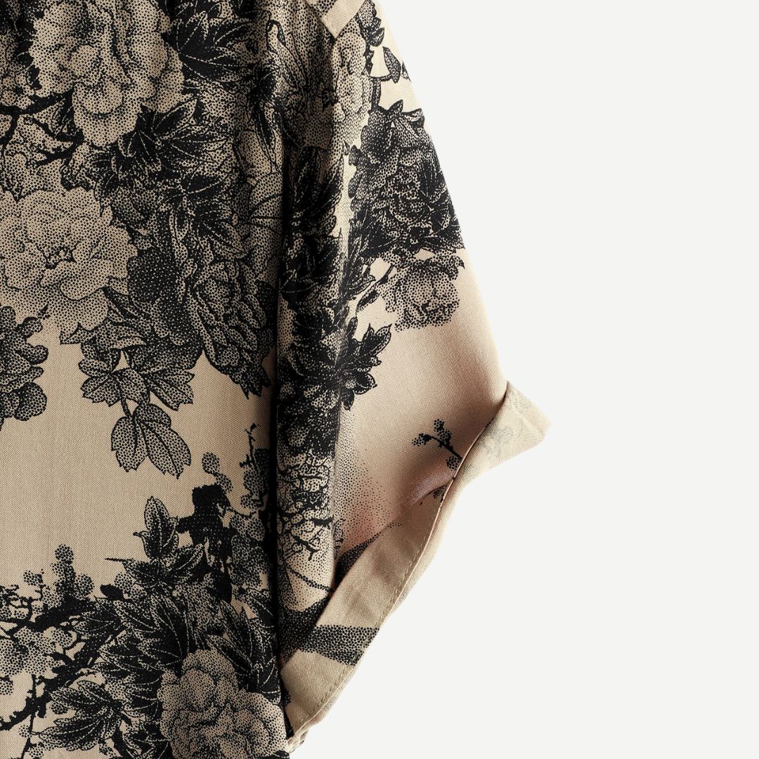 Side close-up of men's floral button down shirt sleeve and hem in beige and black