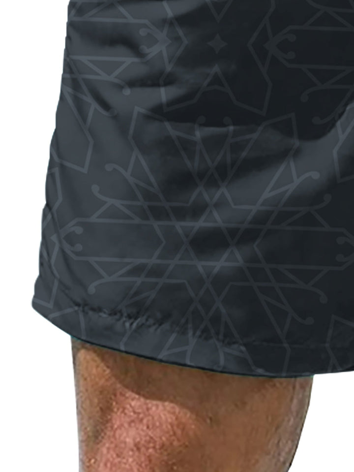Flat lay of black geometric swim shorts for men with white drawstring and side pockets