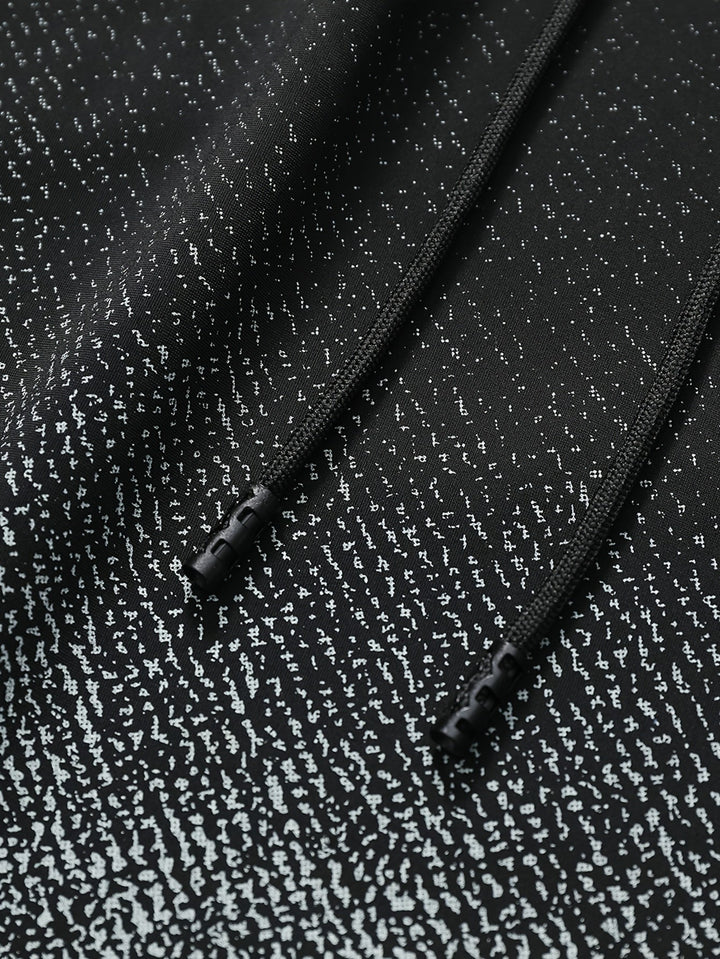 Close-up of black gradient swim shorts showing speckled fabric texture and drawstring detail