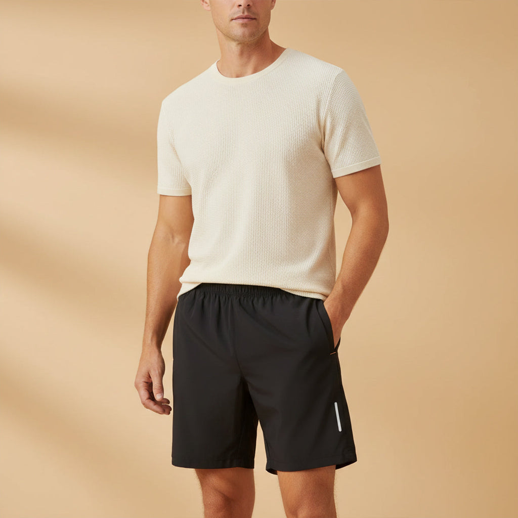 Model wearing black lightweight running shorts with pockets and reflective side accents