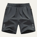Dark gray men's summer running shorts with elastic waist, zip pockets, and reflective side strips