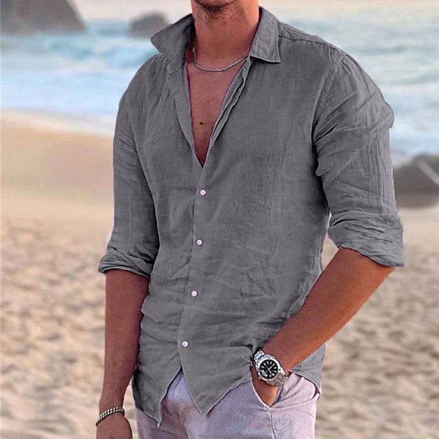 Gray men's summer linen button down long sleeve shirt with rolled sleeves on a beach