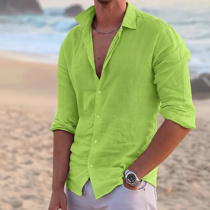 Bright green men's summer linen button down shirt with long sleeves worn on the beach