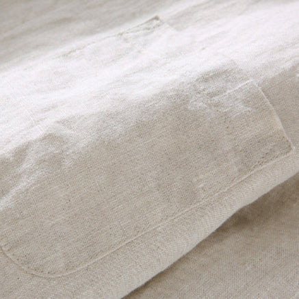 Close-up of beige linen shirt chest pocket and textured fabric on a men's summer button up shirt