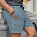 Blue linen shorts for men worn at the side, drawstring waist and relaxed summer fit