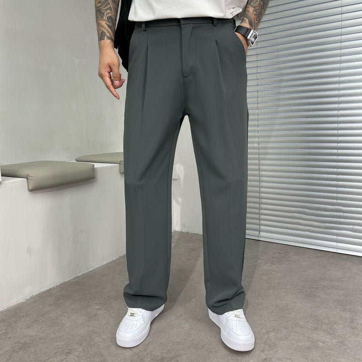 Charcoal gray pleated straight leg linen pants with a tailored waist and wide leg drape