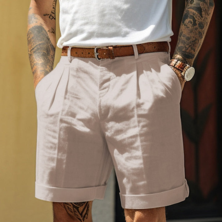 Light beige pleated tailored shorts for men with belt loops, cuffed legs and front crease
